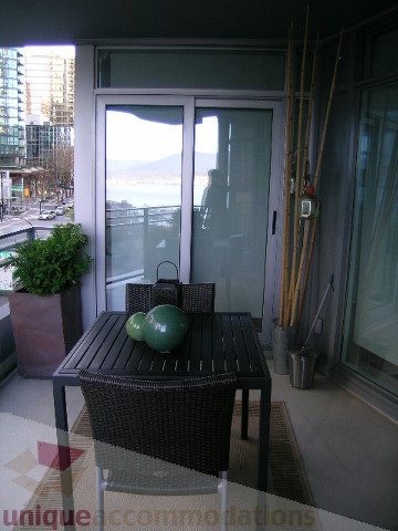 Furnished balcony with sliding glass doors, city view, and patio furniture. - 604 - 1205 West Hastings Street, Vancouver Downtown