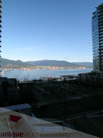Furnished living room with a stunning city view and waterfront access. - 604 - 1205 West Hastings Street, Vancouver Downtown