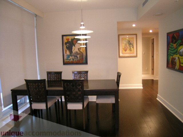 Furnished dining area with modern chandelier, hardwood floors, and artwork on walls. - 604 - 1205 West Hastings Street, Vancouver Downtown
