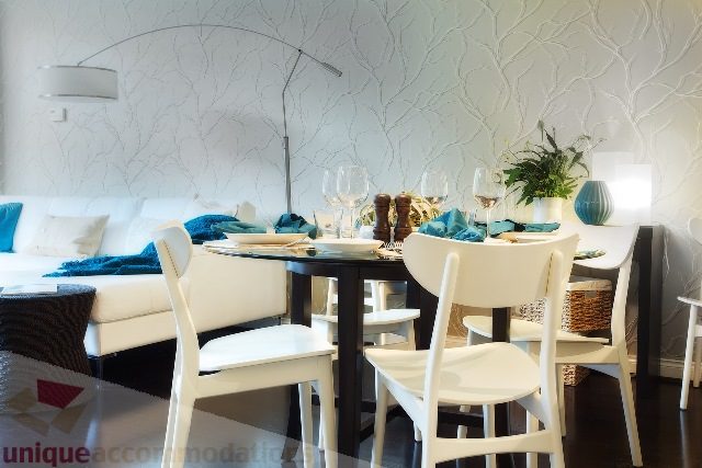Dining room with modern white furniture, textured wallpaper, and a potted plant. - Townhouse 117 - 118 Drake Street, Vancouver Downtown