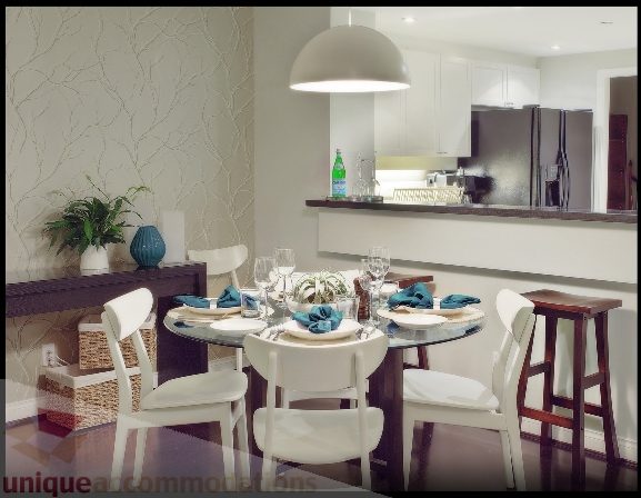 Bright dining area with round table, white chairs, and modern pendant light. - Townhouse 117 - 118 Drake Street, Vancouver Downtown