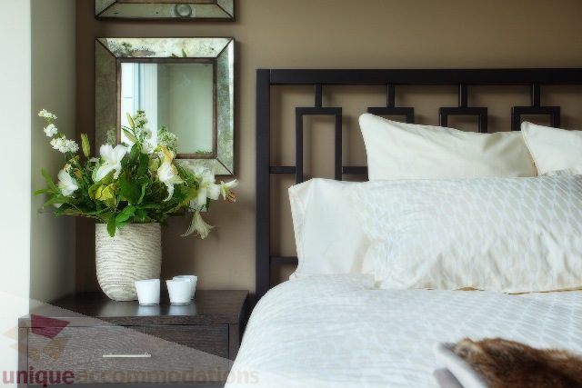 Furnished bedroom with modern headboard and floral decor. - Townhouse 117 - 118 Drake Street, Vancouver Downtown