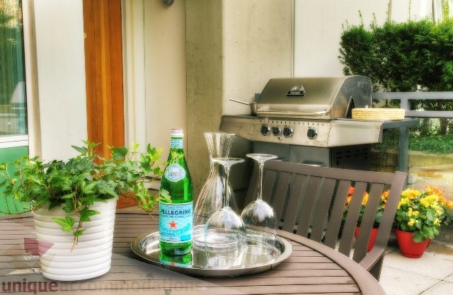 Furnished patio with outdoor grill, potted plants, and water bottles. - Townhouse 117 - 118 Drake Street, Vancouver Downtown
