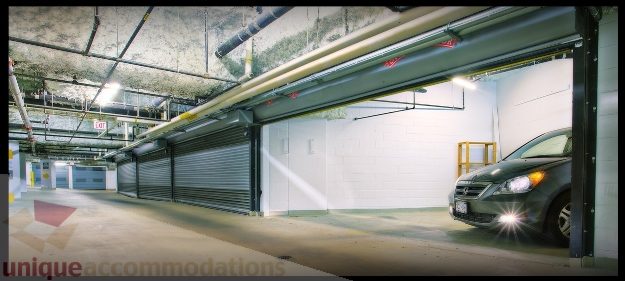 Garage with open doors, concrete floor, and industrial lighting. - Townhouse 117 - 118 Drake Street, Vancouver Downtown