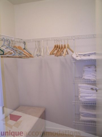 Bright walk-in closet with white hangers and shelving, clean and organized. - 1602 - 1005 Beach Ave., Vancouver Downtown