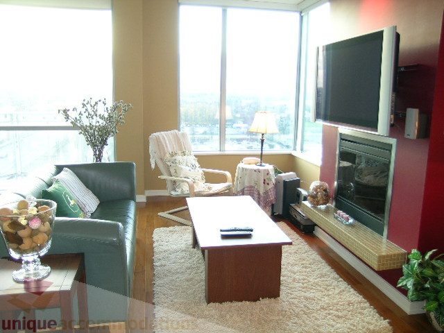 Bright living room with hardwood floors, city view, and modern furnishings. - 1602 - 1005 Beach Ave., Vancouver Downtown