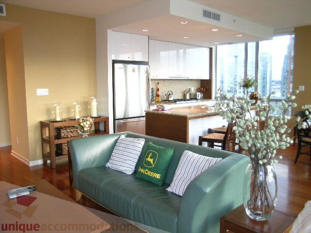 Bright living room with modern furniture, hardwood floors, and a city view. - 1602 - 1005 Beach Ave., Vancouver Downtown