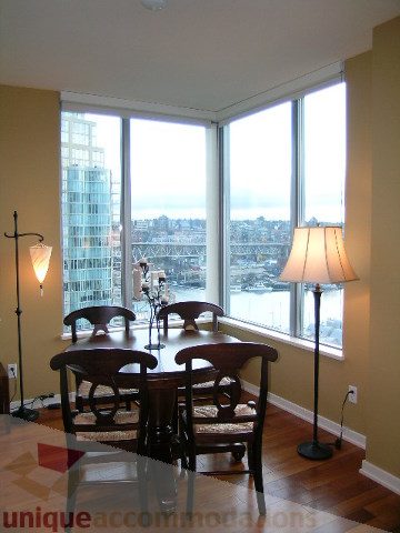 Furnished dining area with hardwood floors, city view, and modern decor. - 1602 - 1005 Beach Ave., Vancouver Downtown