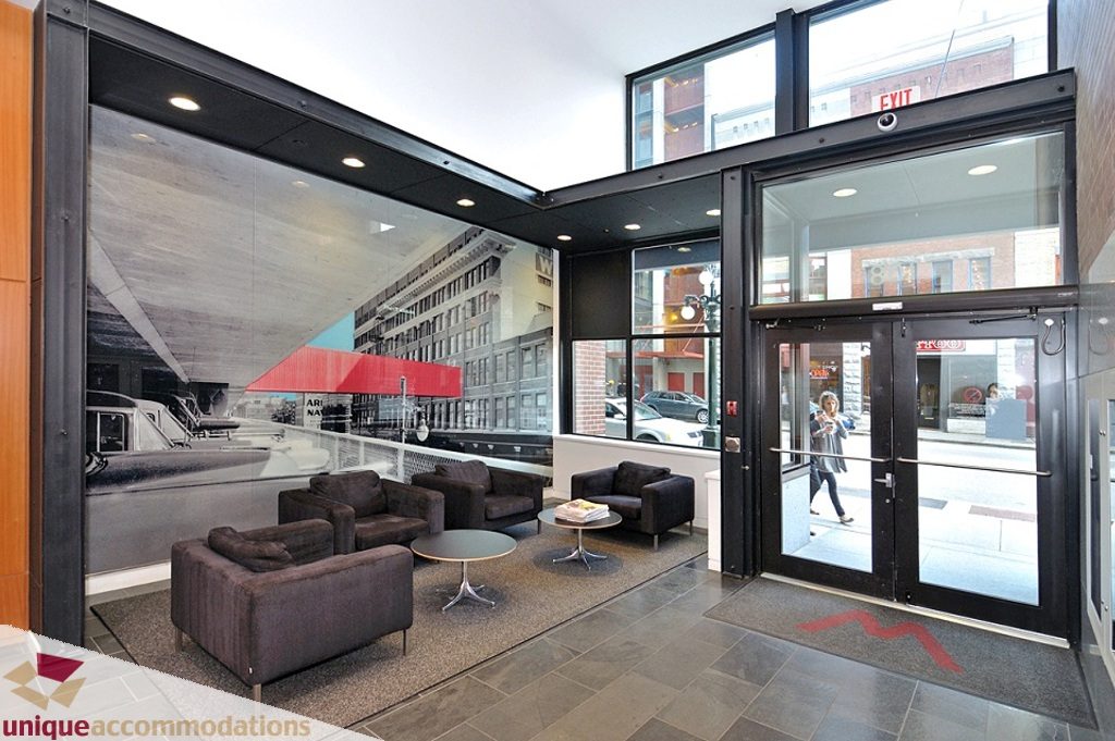 Spacious living room with modern furnishings, large windows offering city views, and sleek countertops. - 1409 - 108 West Cordova, Vancouver Downtown