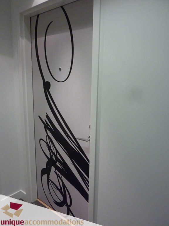 Modern bathroom with artistic black-and-white wall art and sleek white fixtures. - 1409 - 108 West Cordova, Vancouver Downtown