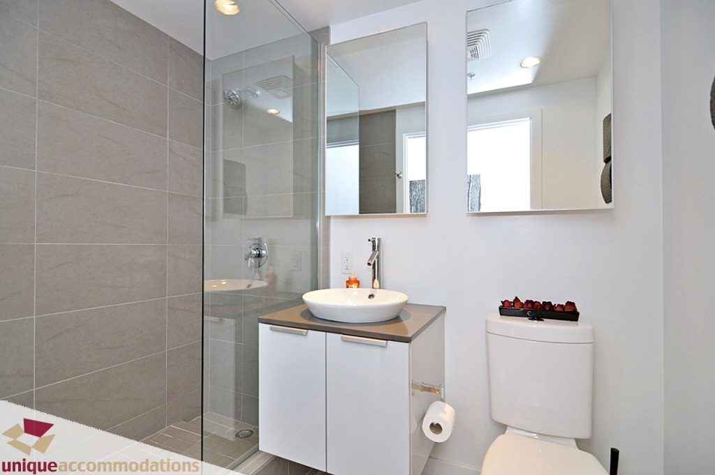 Modern bathroom with sleek white vanity, glass shower, and large mirrors. - 1409 - 108 West Cordova, Vancouver Downtown