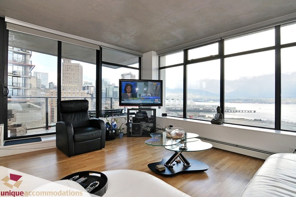 Spacious living room with hardwood floors, a glass coffee table, and a stunning city view. - 1409 - 108 West Cordova, Vancouver Downtown