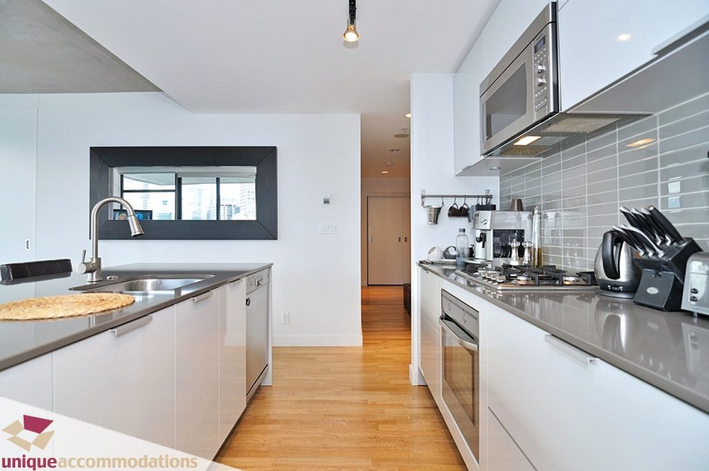 Modern kitchen with sleek countertops, hardwood floors, and a city view. - 1409 - 108 West Cordova, Vancouver Downtown