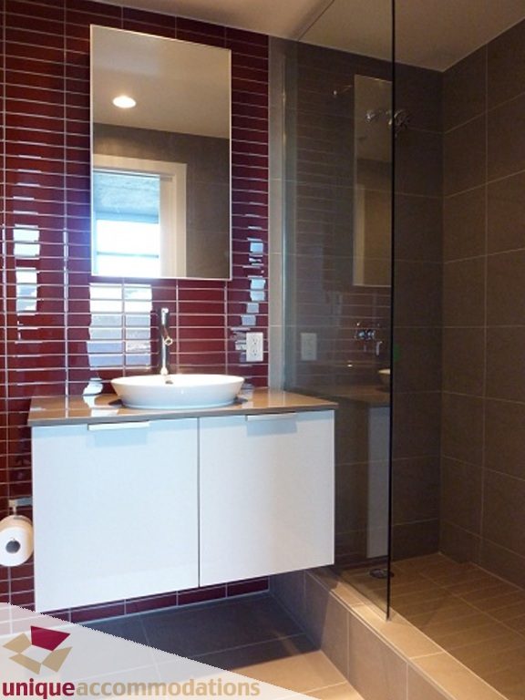 Modern bathroom with sleek white vanity, red accent tiles, and a walk-in shower. - 1409 - 108 West Cordova, Vancouver Downtown