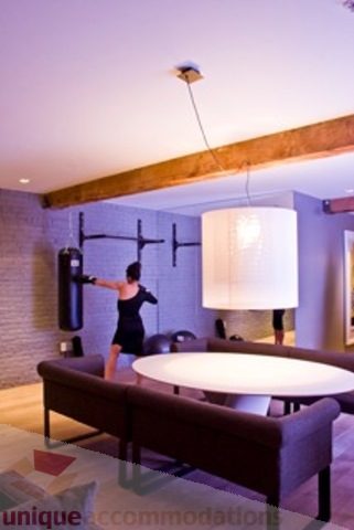 Furnished loft with modern decor, exposed beams, and a large circular table. - 30 - 133 Keefer Street, Vancouver Downtown