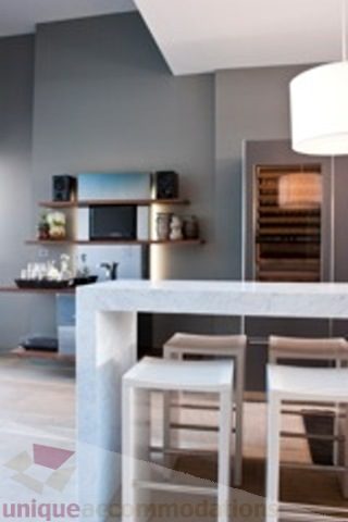 Bright kitchen with modern white countertops and sleek bar stools, showcasing a stylish urban vibe. - 30 - 133 Keefer Street, Vancouver Downtown