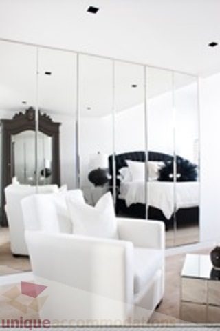 Bright living room with mirrored walls and modern white furniture. - 30 - 133 Keefer Street, Vancouver Downtown