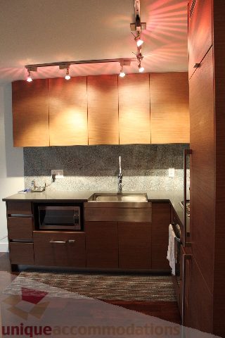 Bright kitchen with modern wood cabinets, stainless steel countertops, and hardwood floors. - 705 - 565 Smithe Street, Vancouver Downtown