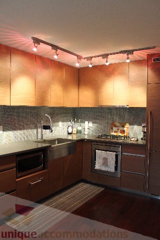 Bright kitchen with dark wood cabinets, granite countertops, and hardwood floors. - 705 - 565 Smithe Street, Vancouver Downtown