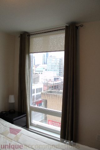 Furnished bedroom with city view and large window. - 705 - 565 Smithe Street, Vancouver Downtown