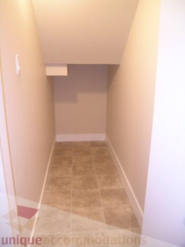 Spacious laundry room with tiled floor and built-in shelves. - 1309 Civic Place Mews, North Vancouver