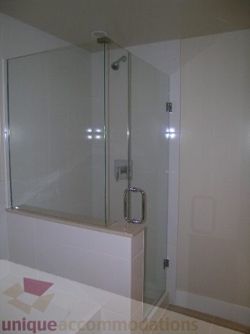 Spacious bathroom with modern glass shower and sleek countertop. - 1309 Civic Place Mews, North Vancouver