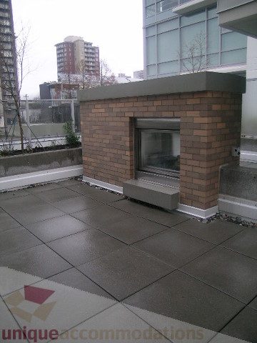 Outdoor patio with brick fireplace and city view. - 1309 Civic Place Mews, North Vancouver