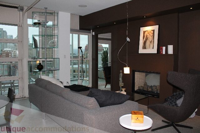 Spacious living room with city view, modern decor, and cozy seating. - 701 - 546 Beatty Street, Vancouver Downtown
