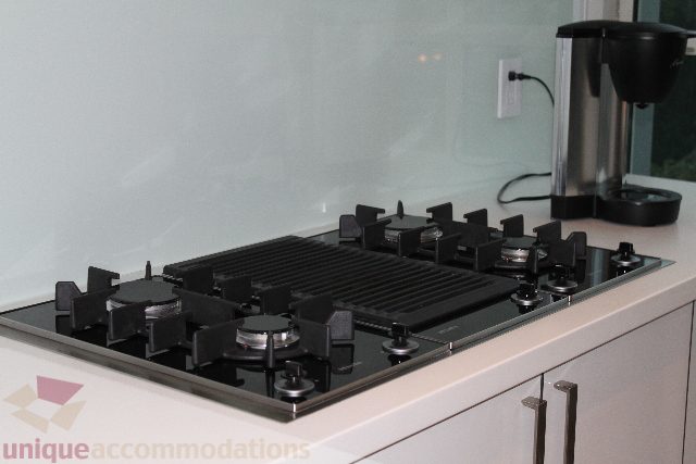 Bright kitchen with modern gas stove and sleek countertop, coffee maker nearby. - 701 - 546 Beatty Street, Vancouver Downtown
