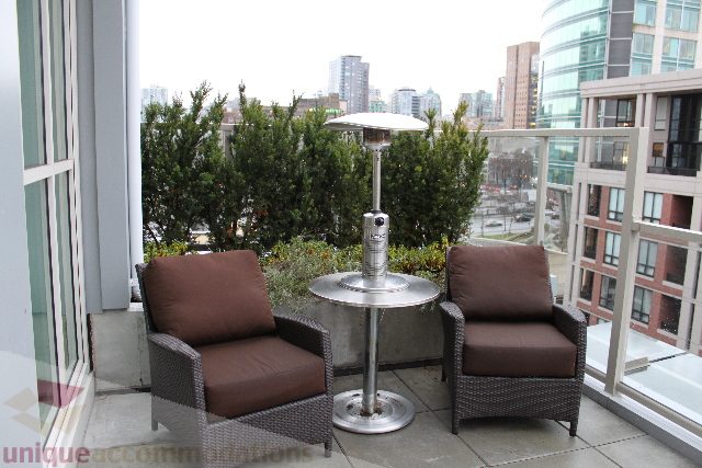 Furnished balcony with city view, patio furniture, and heater. - 701 - 546 Beatty Street, Vancouver Downtown