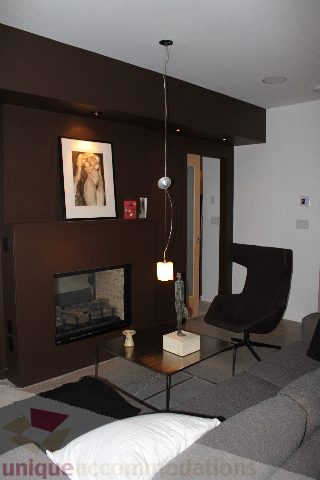 Bright living room with modern fireplace, sleek furniture, and hanging pendant light. - 701 - 546 Beatty Street, Vancouver Downtown