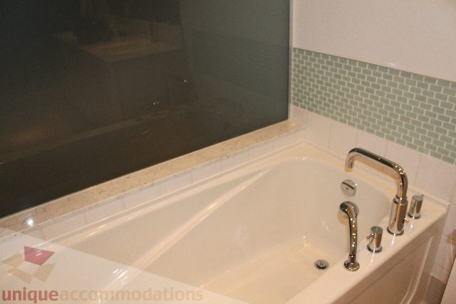 Bathroom with modern sink, green tile backsplash, and large mirror. - 701 - 546 Beatty Street, Vancouver Downtown