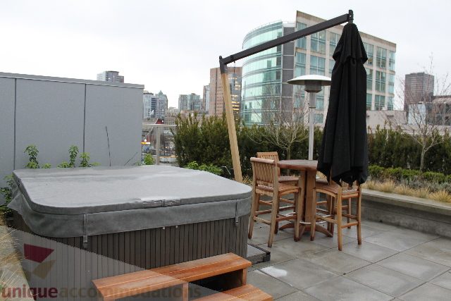 Furnished rooftop patio with city view, modern furniture, and outdoor seating. - 701 - 546 Beatty Street, Vancouver Downtown