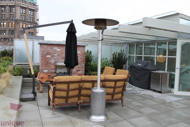 Furnished patio with outdoor furniture, brick wall, and city view. - 701 - 546 Beatty Street, Vancouver Downtown