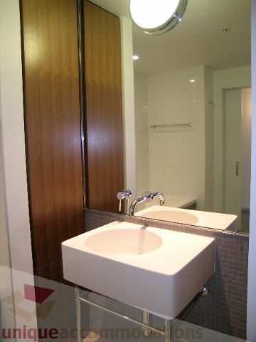 Modern bathroom with white sink and wooden cabinets. - 216 - 388 West 1st Avenue, Vancouver West Side