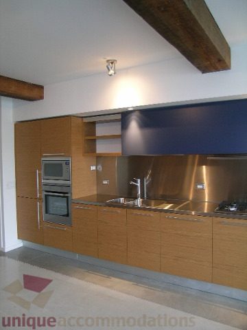 Bright kitchen with modern cabinetry, stainless steel appliances, and a sleek countertop. - 216 - 388 West 1st Avenue, Vancouver West Side