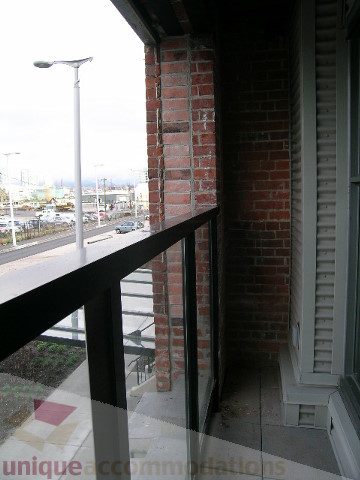 Bright balcony with brick wall, city view, and modern railing. - 216 - 388 West 1st Avenue, Vancouver West Side