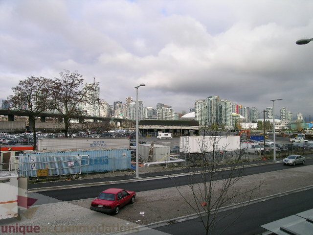 Bright living room with city view and modern furnishings. - 216 - 388 West 1st Avenue, Vancouver West Side