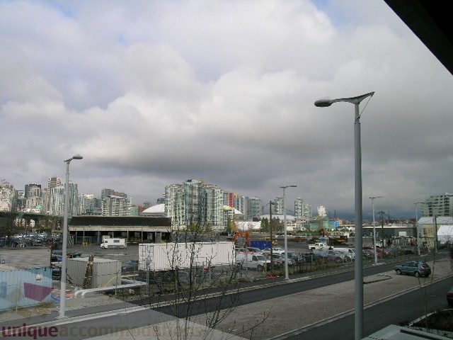 Bright living room with city view and modern furnishings. - 216 - 388 West 1st Avenue, Vancouver West Side