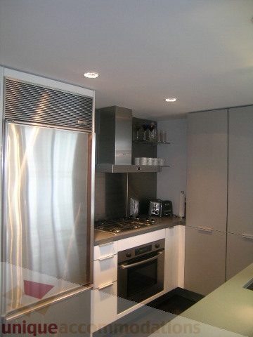 Bright kitchen with stainless steel appliances and white countertops. - 1106 - 788 Richards Street, Vancouver Downtown