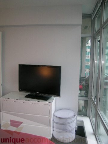 Bright living room with large windows, city view, and modern furniture. - 1106 - 788 Richards Street, Vancouver Downtown