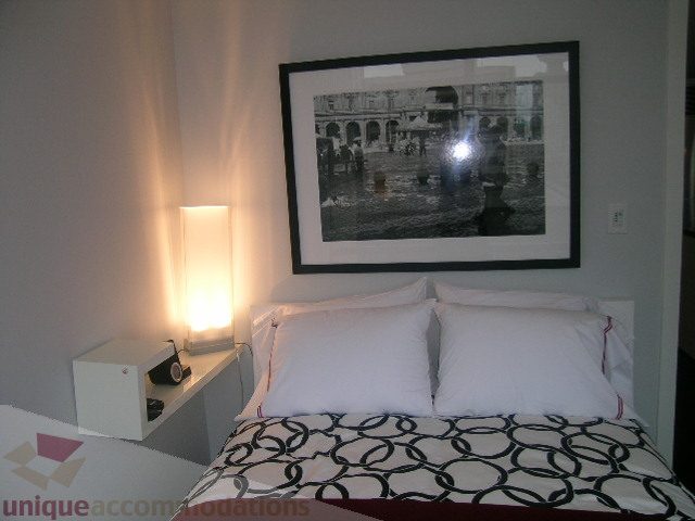 Furnished bedroom with black and white circular patterned bedding and modern artwork above the bed. - 1106 - 788 Richards Street, Vancouver Downtown