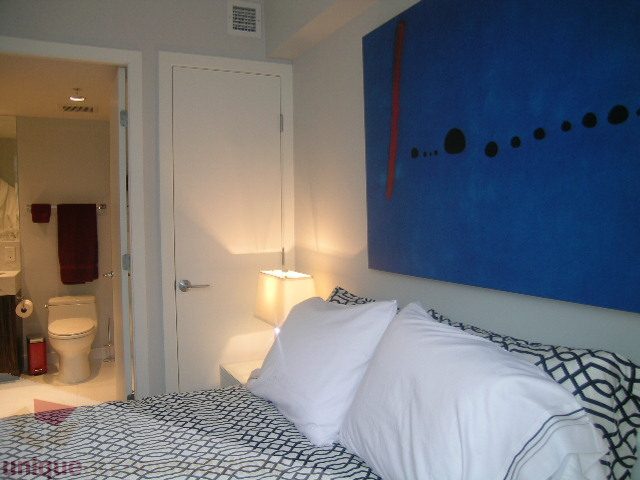 Furnished bedroom with blue accent wall and modern decor. - 1106 - 788 Richards Street, Vancouver Downtown