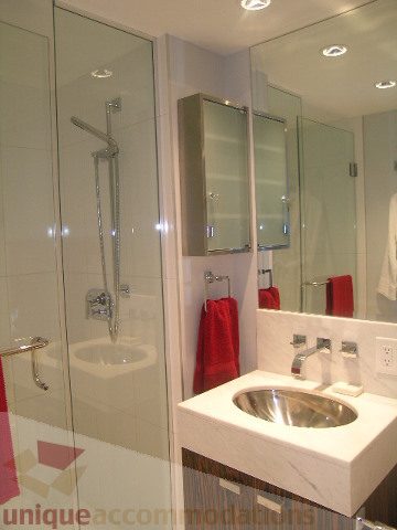 Bright bathroom with modern sink, glass shower, and red accents. - 1106 - 788 Richards Street, Vancouver Downtown