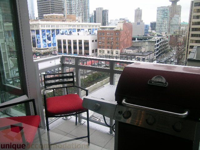 Bright balcony with city view, furnished seating, and a BBQ grill. - 1106 - 788 Richards Street, Vancouver Downtown