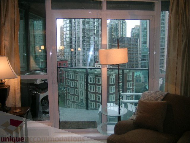 Furnished living room with city view and large windows. - 907 - 1189 Melville Street, Vancouver Downtown
