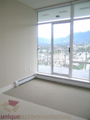 Spacious living room with large windows offering a stunning city view and natural light. - 1903 - 1320 Chesterfield Street, North Vancouver