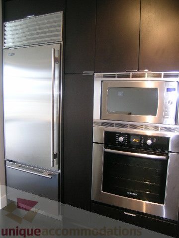 Modern kitchen with stainless steel appliances and sleek black cabinets. - 1903 - 1320 Chesterfield Street, North Vancouver