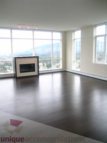 Spacious living room with hardwood floors, large windows, and a city view. - 1903 - 1320 Chesterfield Street, North Vancouver