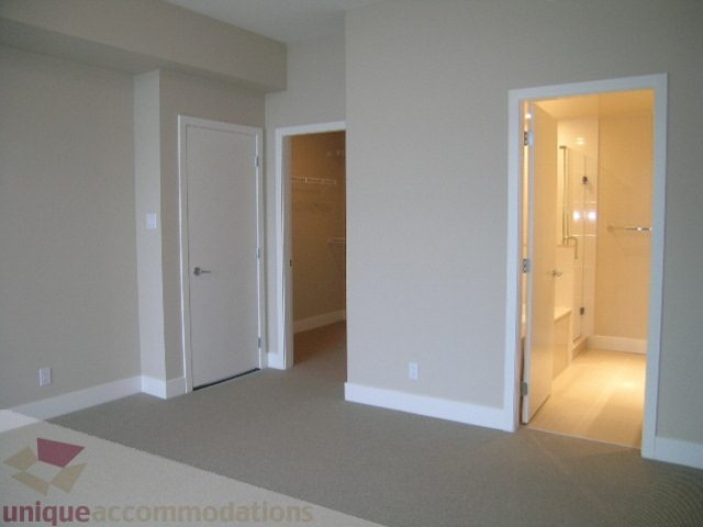 Spacious living room leading to a well-lit den with sliding glass doors and a cozy ambiance. - 1903 - 1320 Chesterfield Street, North Vancouver